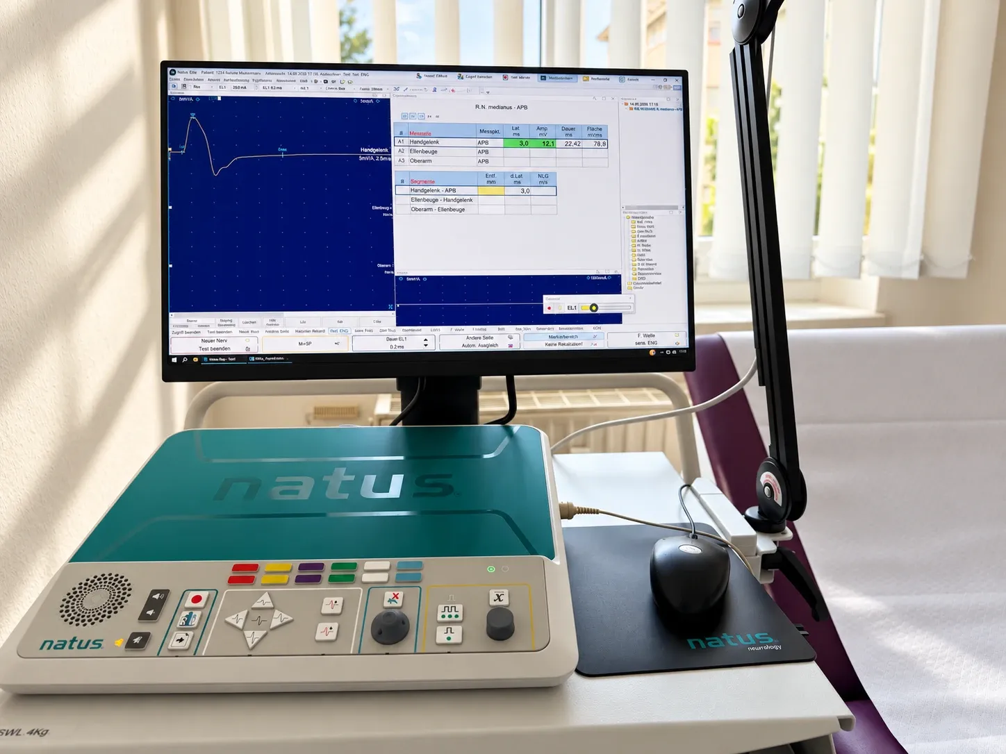 Messplatz für Nervenleitmessung und EMG: Monitor mit Messkurve, Steuerpult und Untersuchungsliege am Fenster